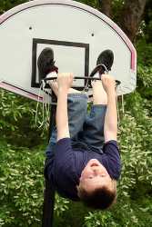 Junge ist in einen Basketballkorb geklettert