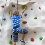 Kind beim Klettern an einer Kletterwand