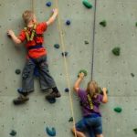 Junge und Mädchen beim Klettern an einer Kletterwand