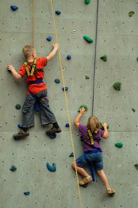 Junge und Mädchen beim Klettern an einer Kletterwand