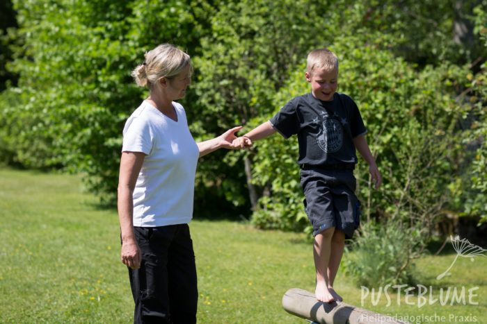 Ein Junge balanciert an der Hand von Birgit Darda.