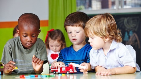 Kinder spielen zusammen im Kindergarten mit einer Feuerwehr