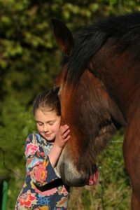 Mädchen schmust mit Pferd