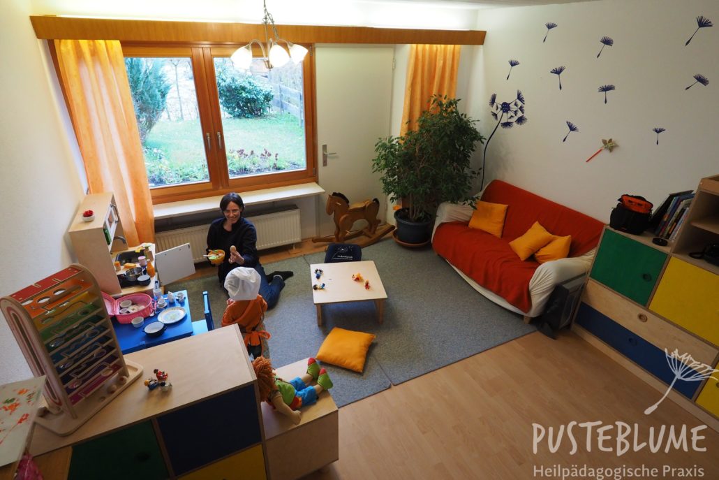 Gesine Herzog spielt mit einem kleinen Jungen im Praxisraum in Reit im Winkl.